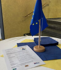 Tisch mit EU-Flagge und Programm