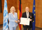 Regierungspräsidentin Dr. Susanne Weizendörfer (links) überreicht das DLRG-Steckkreuz an Thomas Kurewitz (rechts).